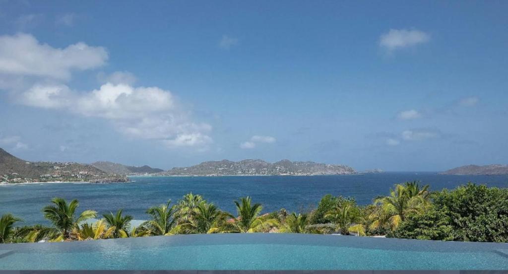 a view of the ocean from a resort swimming pool at Breathtaking 6 BR Villa with Infinity Pool in Pointe Milou