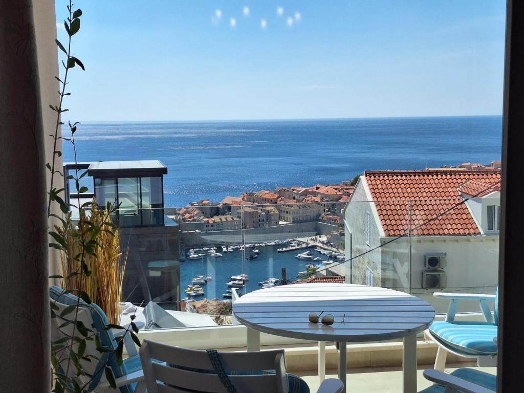 a table and chairs on a balcony with a view of the water at Luxury Apartment Moobl - Free parking in Dubrovnik