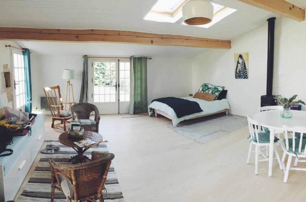 uma sala de estar com uma cama e uma mesa em Loft atypique pour 2 personnes em Nieulle-sur-Seudre
