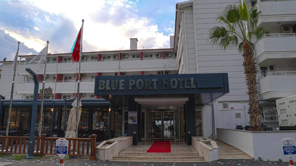 un hotel de punto azul con una palmera delante de él en Blue Port Hotel, en Burhaniye