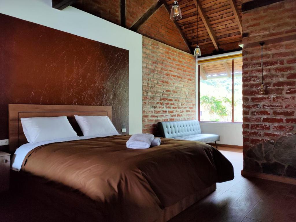 バーニョスにあるLa Quinta Mansión Loftsのレンガの壁、大きなベッド付きのベッドルーム1室