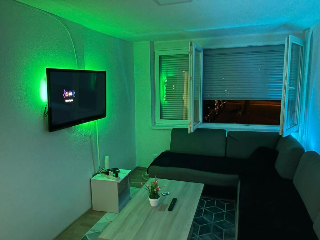 a living room with a couch and a green light at stan na dan in Zenica