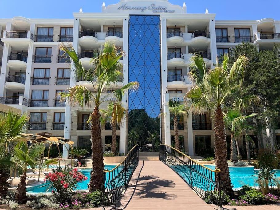 a hotel with palm trees in front of a building at Apartament Harmony in Sunny Beach