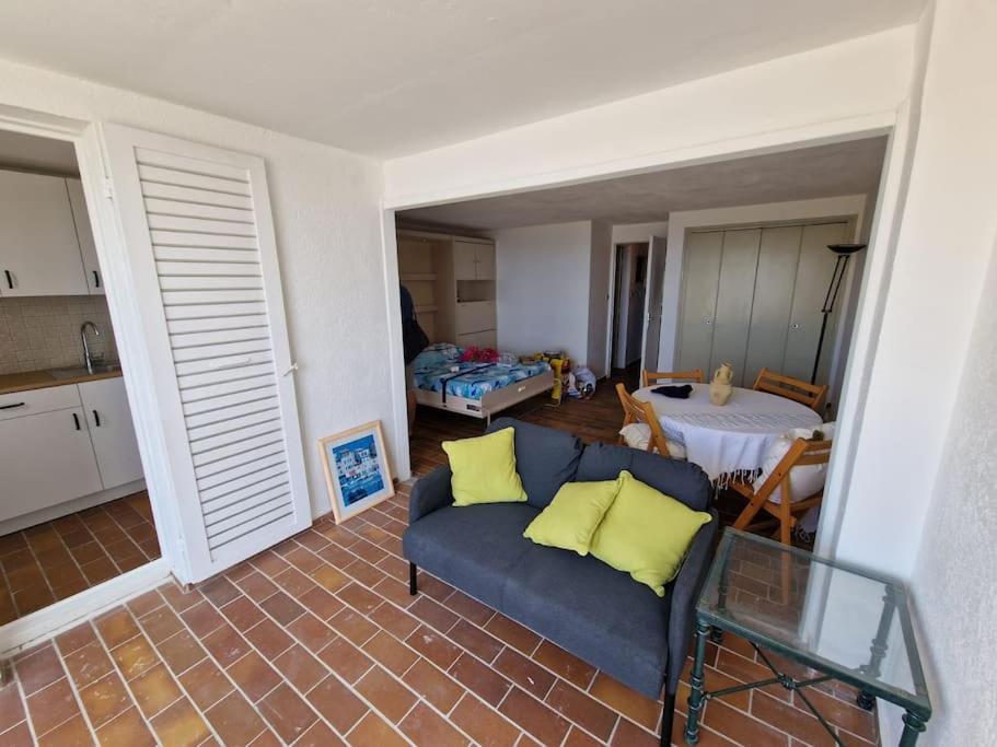 ein Wohnzimmer mit einem blauen Sofa und einem Tisch in der Unterkunft Une parenthèse au Frioul in Marseille