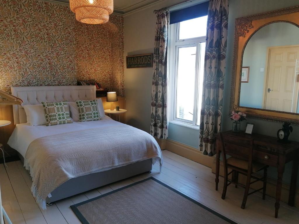 sypialnia z łóżkiem, oknem i lustrem w obiekcie No. 30 w mieście Aberdare