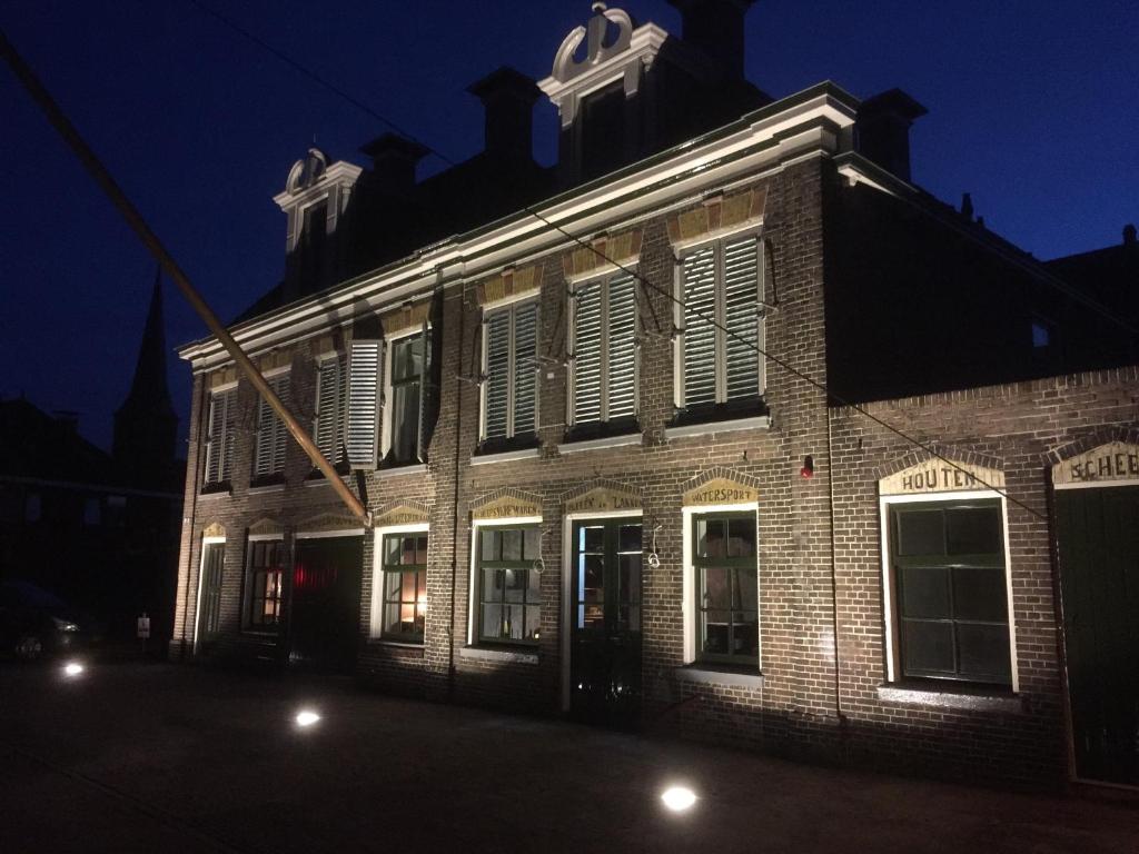 een oud bakstenen gebouw met 's nachts gesloten ramen bij Hotel Lemmer in Lemmer