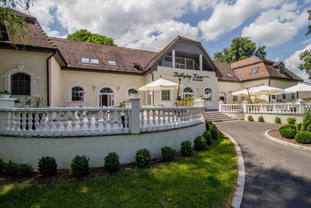 ein Haus mit einem weißen Zaun davor in der Unterkunft Batthyány Kúria in Zalacsány