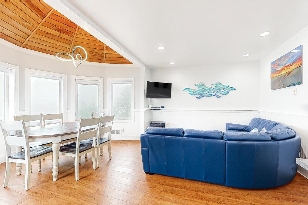 a living room with a blue couch and a table at Berni's Crow's Nest in Oceanside