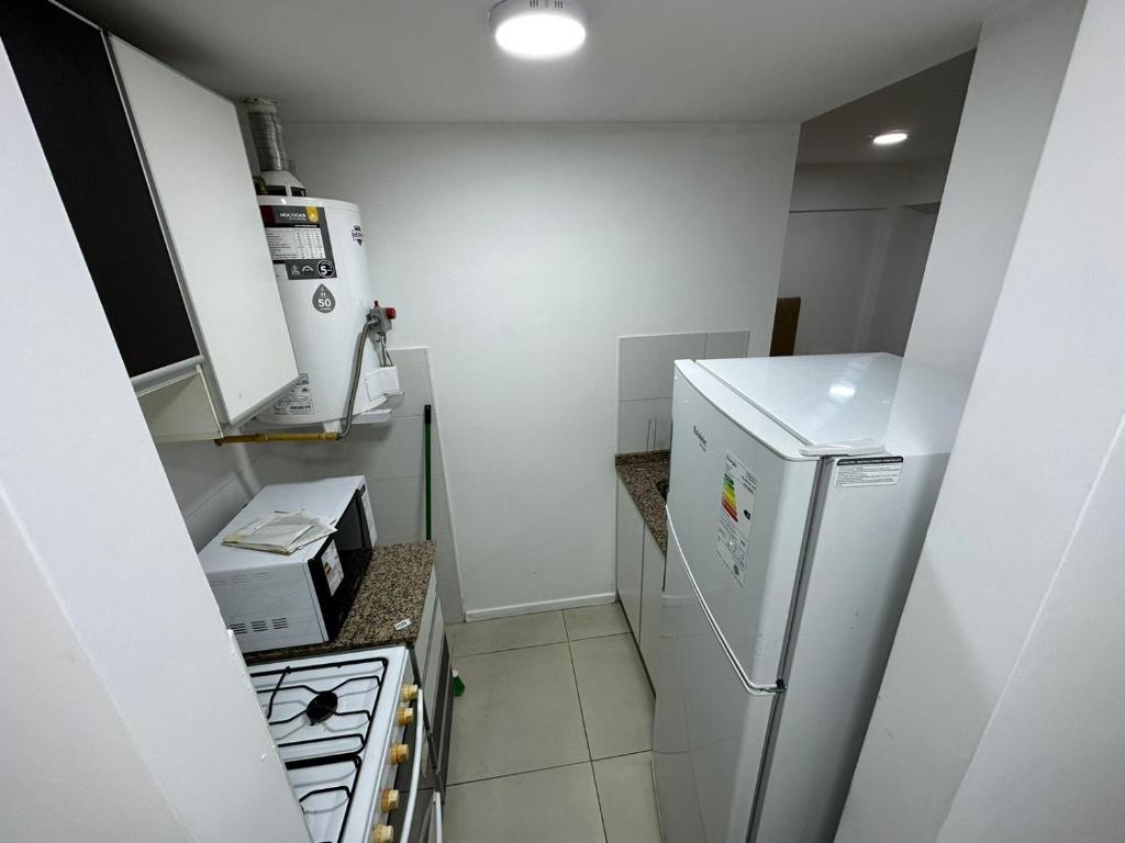 Il comprend une petite cuisine équipée d'un réfrigérateur et d'une cuisinière. dans l'établissement Depto moderno, buena ubicacion., à Rosario