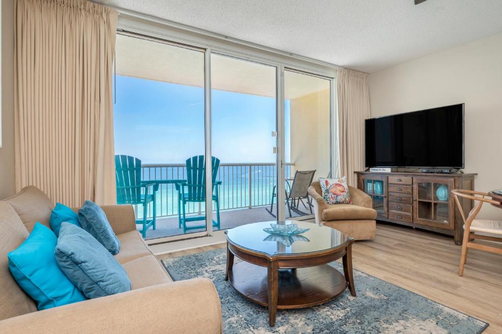 uma sala de estar com um sofá e uma televisão de ecrã plano em Stunning Ocean & Sunset Views, Direct Beach Access with 2 King Bedrooms at Panama City Beach, Fl em Panama City Beach