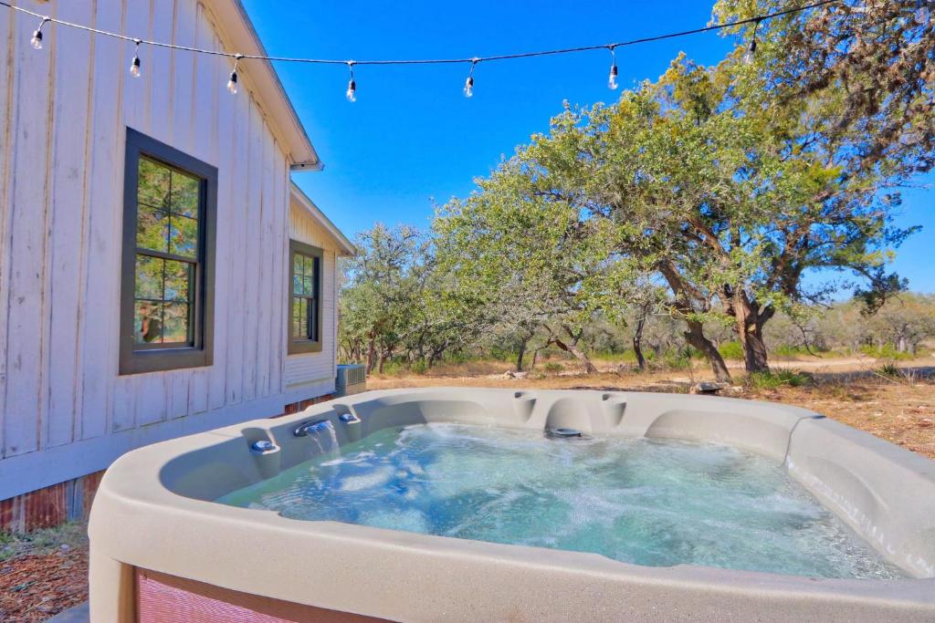 a hot tub in front of a house at Serendipity Farmhouse in Wimberley