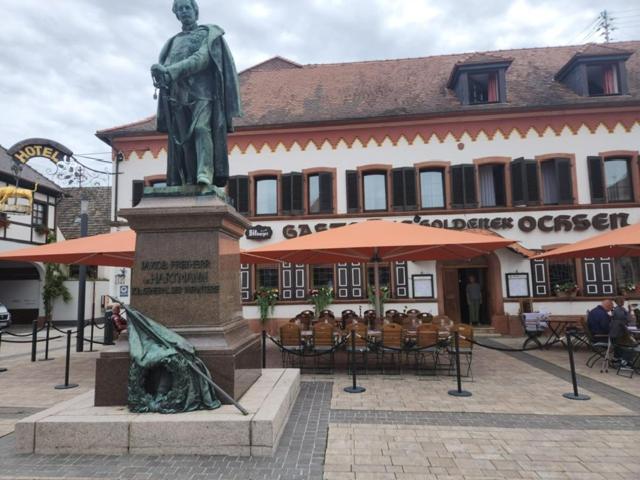 a statue of a woman standing in front of a building at Hotel zum Goldenen Ochsen in Maikammer