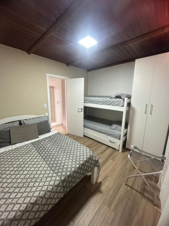 um quarto com uma cama e 2 beliches em Village ITACIMIRIM em Camaçari