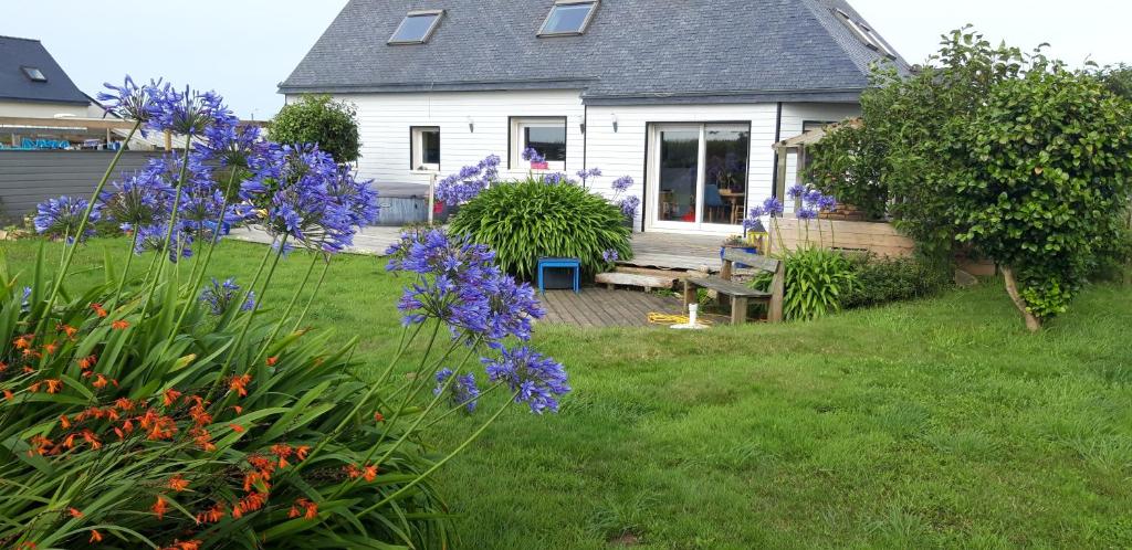 a house with purple flowers in the yard at Chambre d'hôtes de la voie bleue. in Plouguerneau