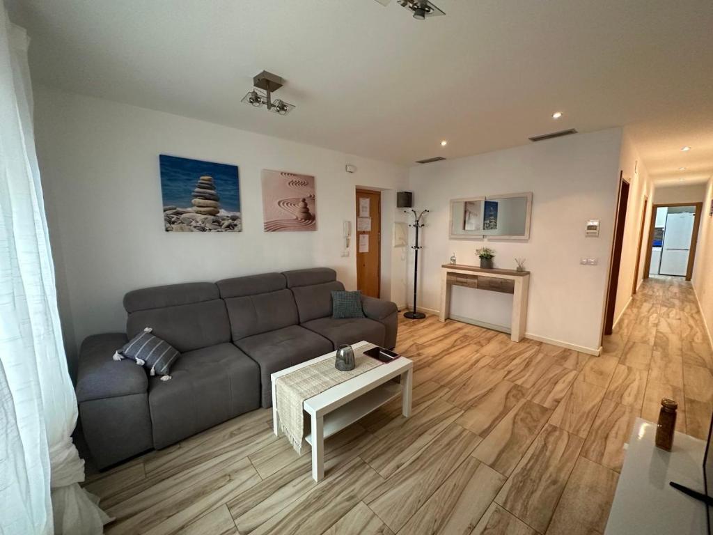 ein Wohnzimmer mit einem Sofa und einem Tisch in der Unterkunft CAROLINAS SUIT in Alicante