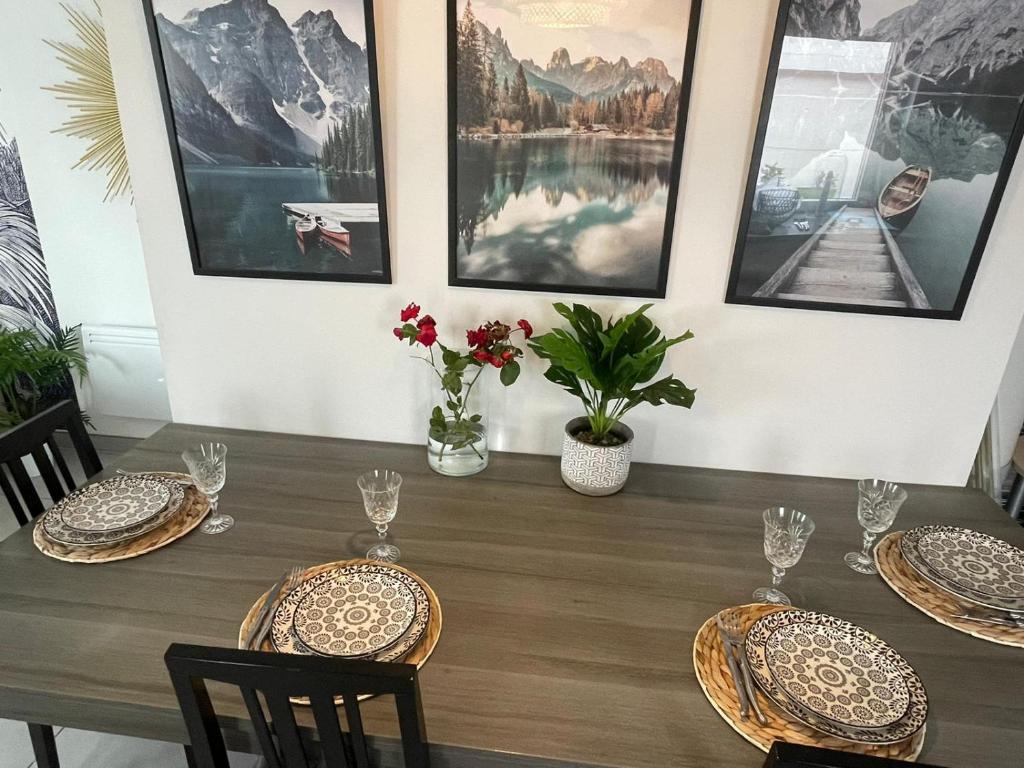 a dining room with a table with chairs and pictures on the wall at LIVABLŌM "Maison et Parking Privée" 
