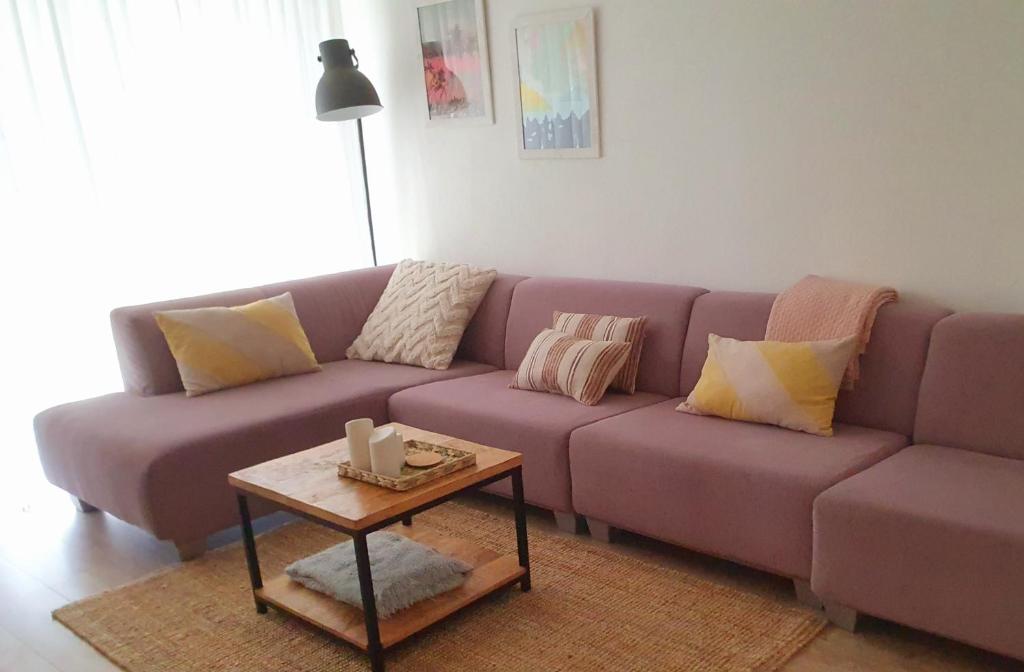 - un canapé violet dans le salon avec une table dans l'établissement 't Hoekhuisje, à Katwijk aan Zee