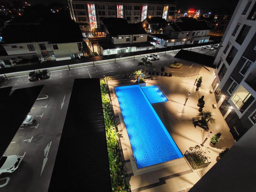 an overhead view of a pool in a city at night at Gem Suites Minimalist 2BR 4beds Entire Apartment in Kuching