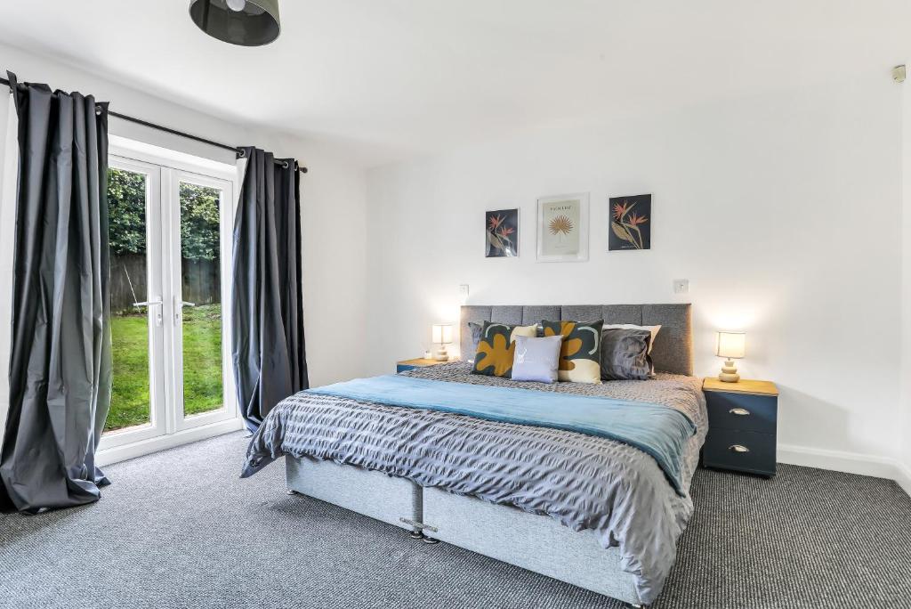 um quarto com uma cama e uma grande janela em Silver Stag Properties, 3 BR Dormer Bungalow em Thringstone