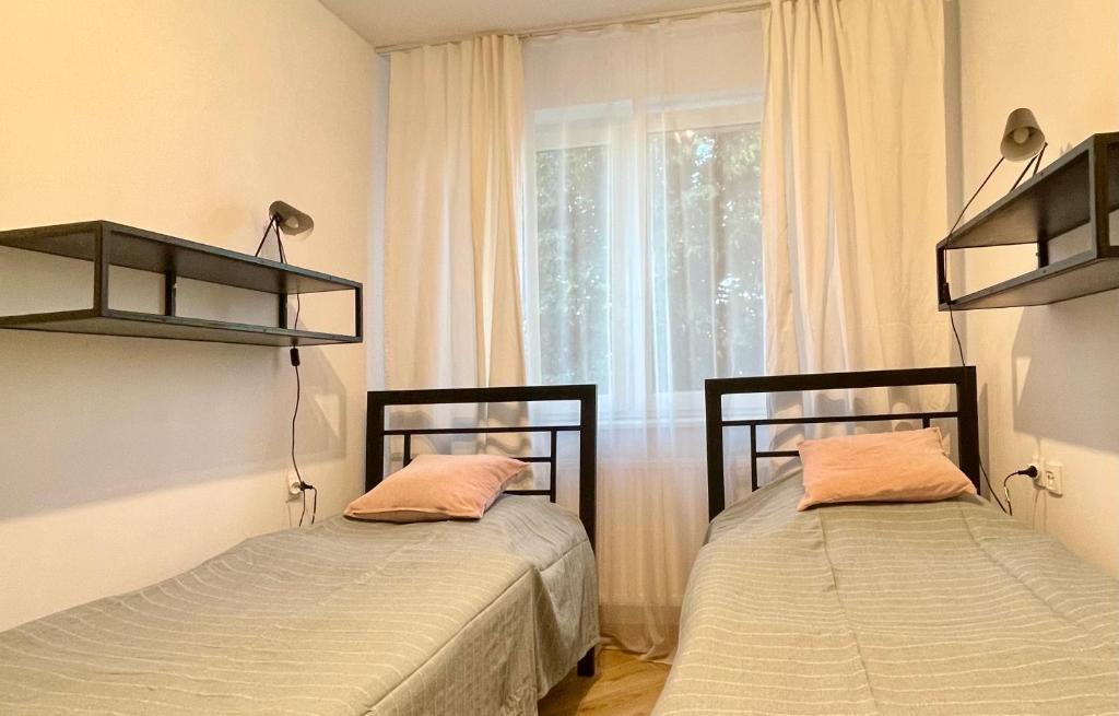 two beds in a room with a window at Apartament KaMaRo in Słubice