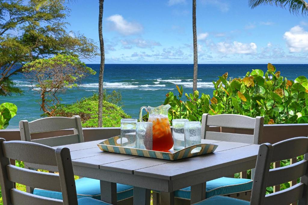 a table with a tray of drinks on top of the ocean at Kaha Lani #222 in Lihue