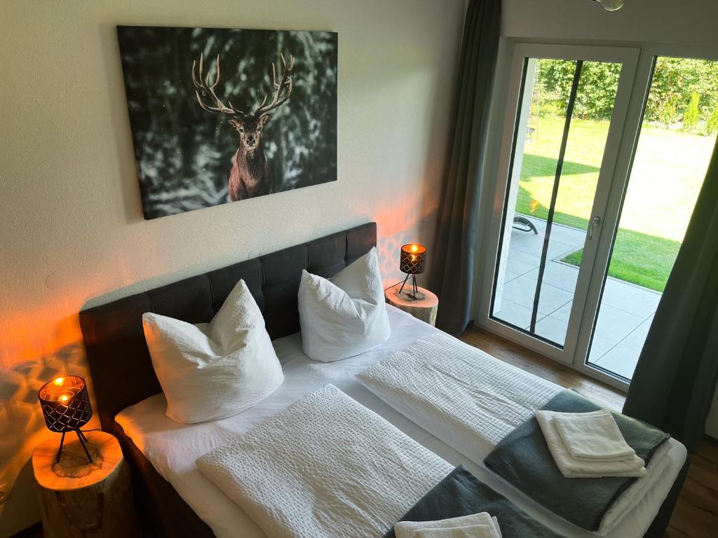 - une chambre dotée d'un lit avec une photo de cerf sur le mur dans l'établissement Luxusferienwohnung mit Sauna - NEUBAU, à Ofterschwang
