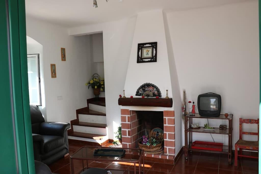ein Wohnzimmer mit einem Kamin und einem TV in der Unterkunft Casa de Alpalhão in Alpalhão