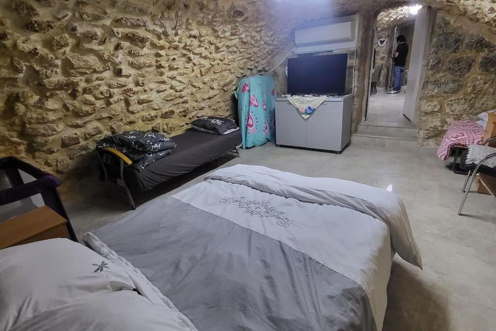 a living room with a couch and a tv at historic luxury cave in Jerusalem