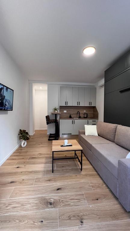 ein Wohnzimmer mit Sofa und Tisch in der Unterkunft INFINITY Studioapartman, Self Check-in in Posušje