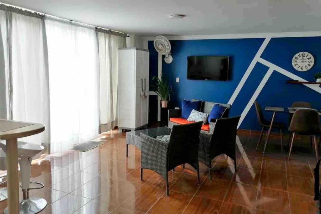 sala de estar con mesa y pared azul en Tucurinca, en Santa Marta