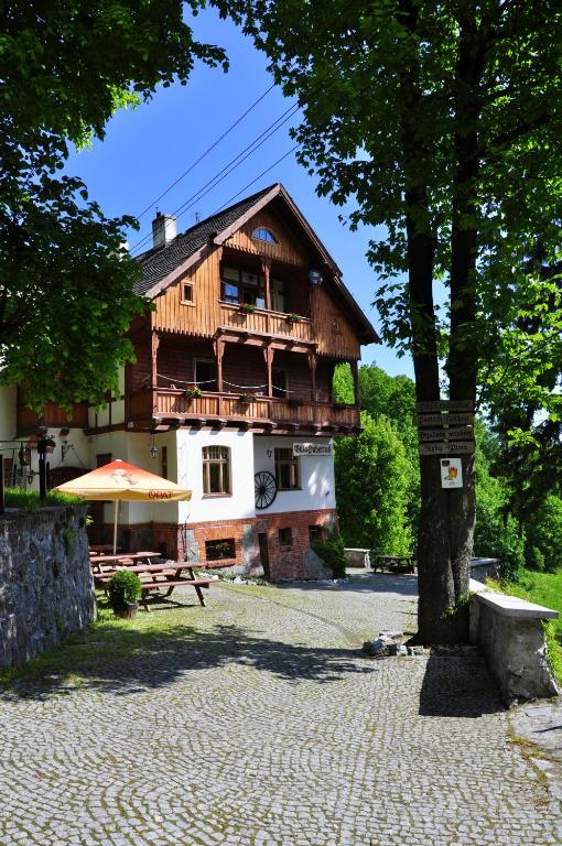 a wooden house with a table and a tree at Villa Hubertus in Srebrna Góra
