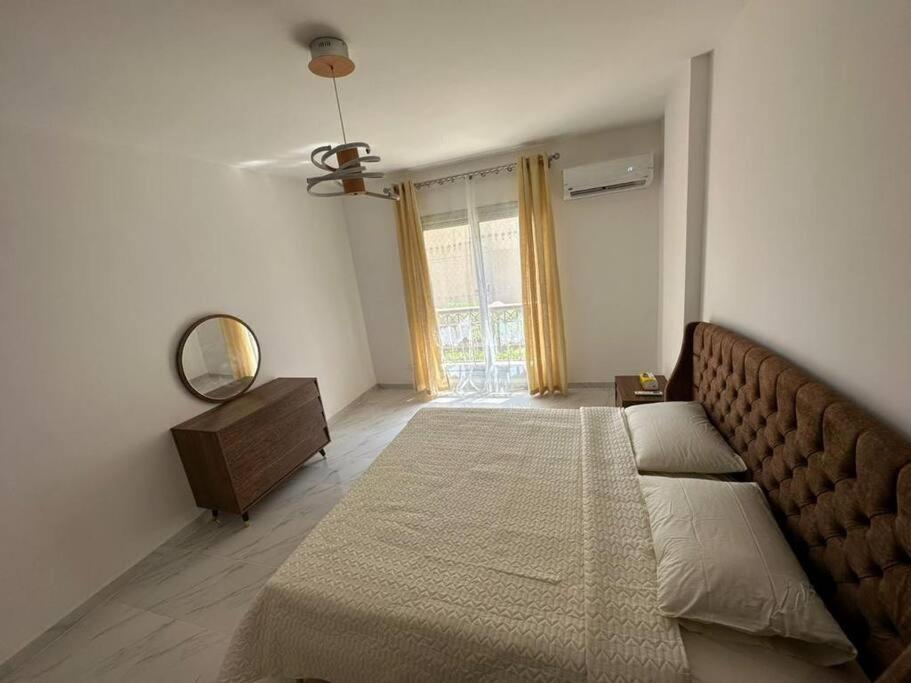 a bedroom with a large bed and a mirror at شقة في مدينتي بي 2 جديدة in Madinaty