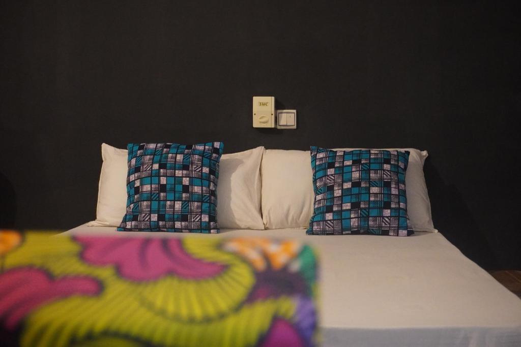 a bedroom with a bed with two pillows on it at Au cœur de Ouidah 2 in Ouidah