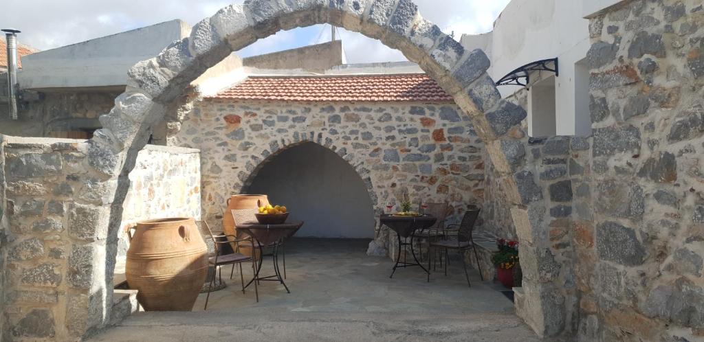 an archway in a stone building with tables and chairs at Vilaeti Artemis in Agios Konstantinos