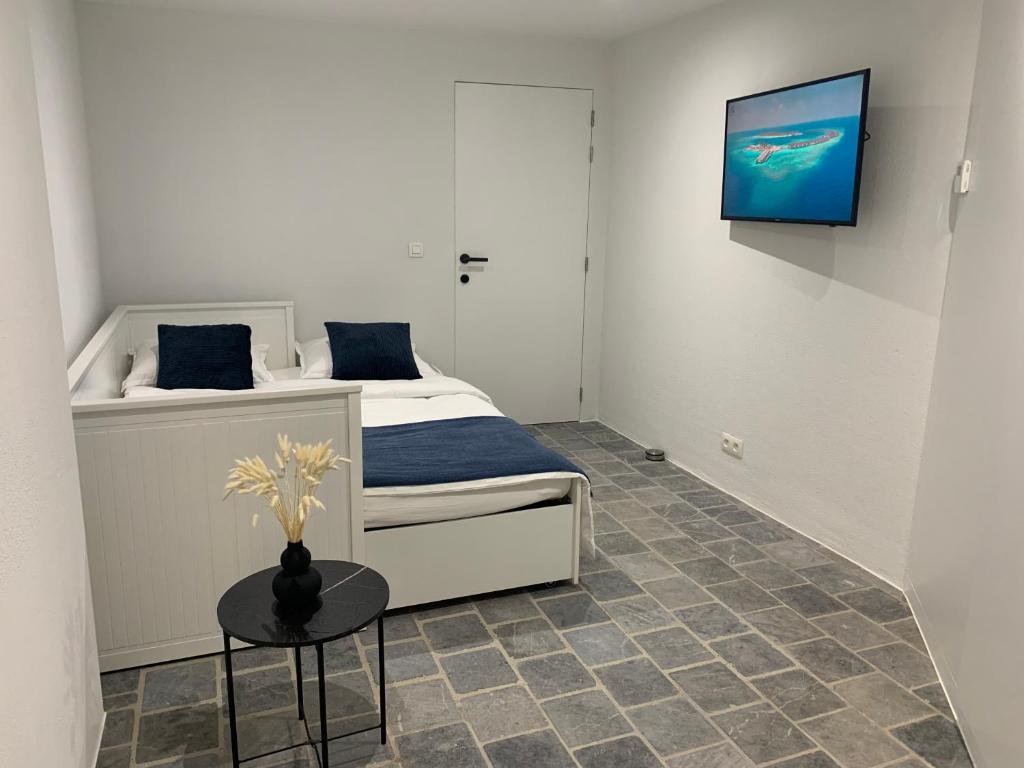 een slaapkamer met een bed en een tv aan de muur bij Residentie Don in Brugge