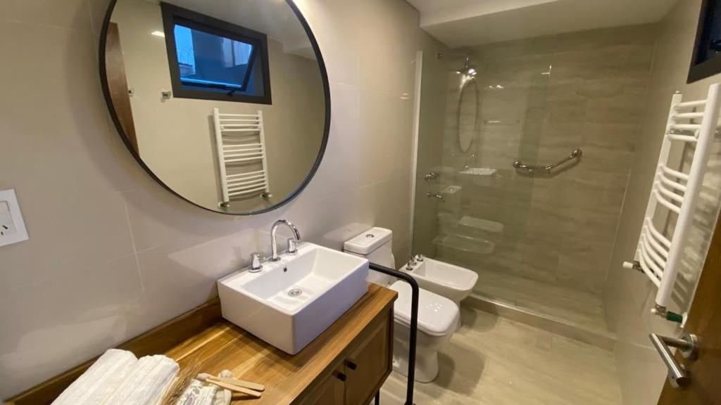 a bathroom with a sink and a mirror and a shower at 718 Rufino Petit Hotel in Mendoza