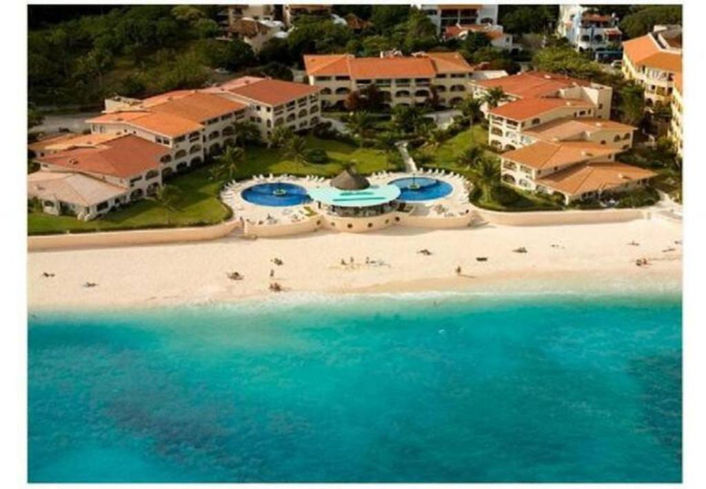 an aerial view of a resort on a beach at Departamento frente al mar con dos recámaras y seguridad 24 h a dos cuadras de la Quinta Avenida in Playa del Carmen