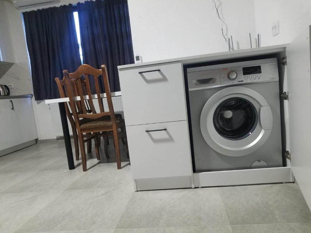 a washing machine in a kitchen with a chair at Private apartment in Tbilisi City