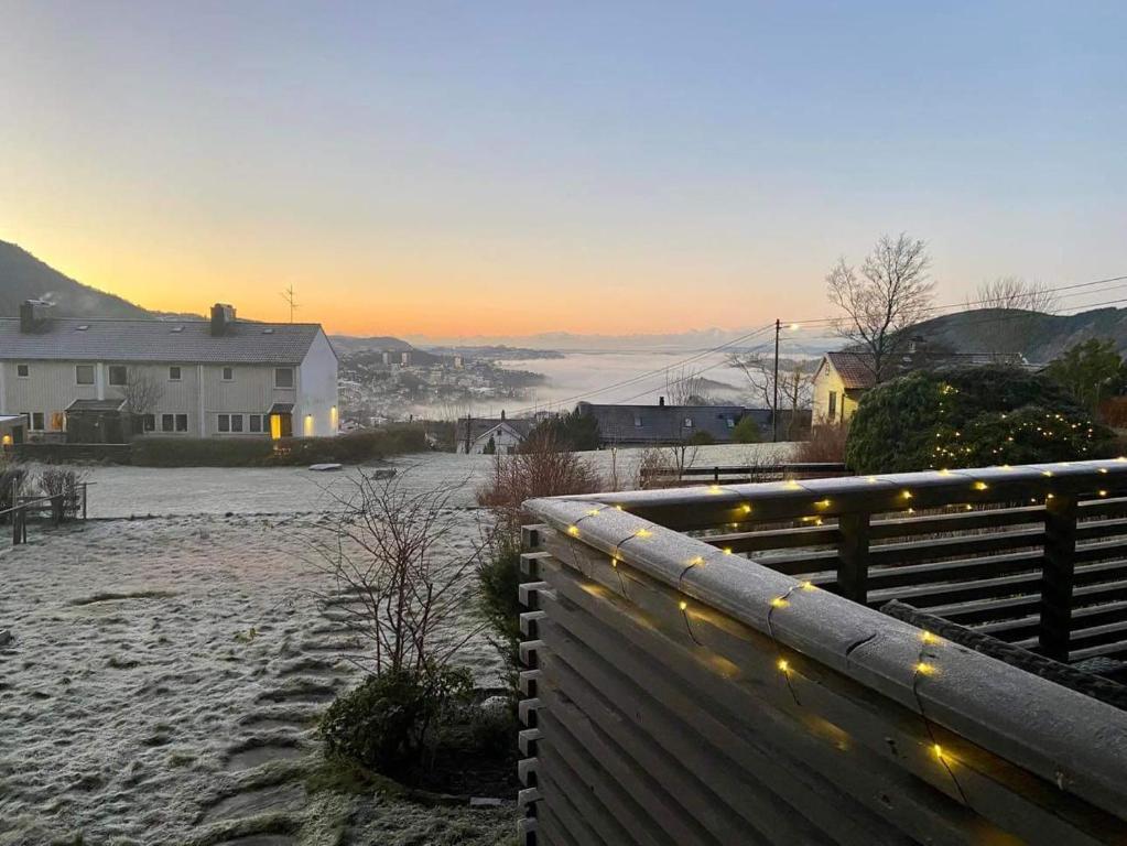 une clôture avec des lumières de Noël à côté d'une maison dans l'établissement Guesthouse on the footstep of Mount Ulriken, à Bergen