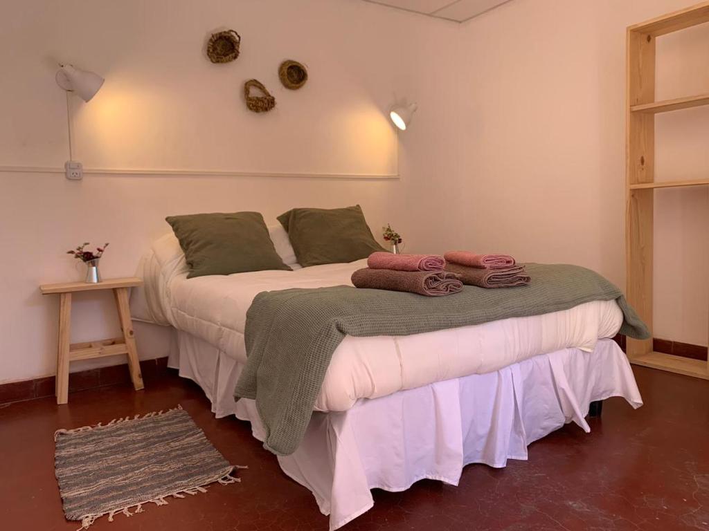 a bedroom with a bed with towels on it at Buena Vista Hostel in Humahuaca