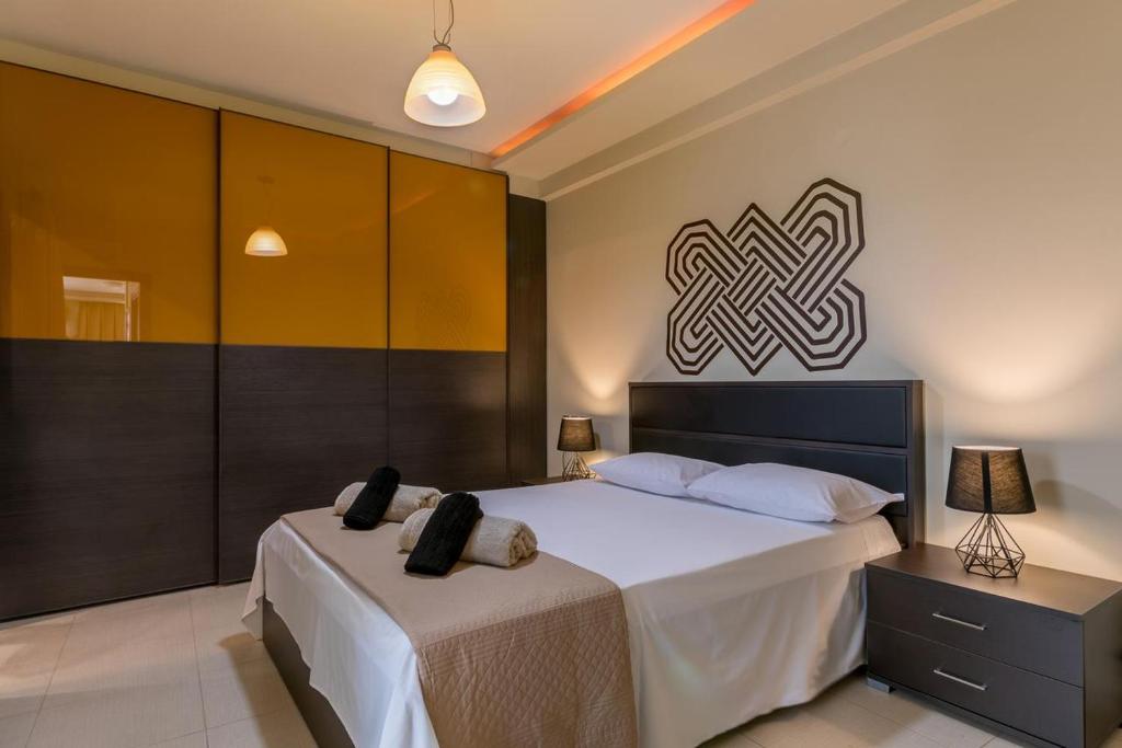 een slaapkamer met een groot wit bed met een hoofdeinde bij Ionias Apartment in Heraklion in Heraklion