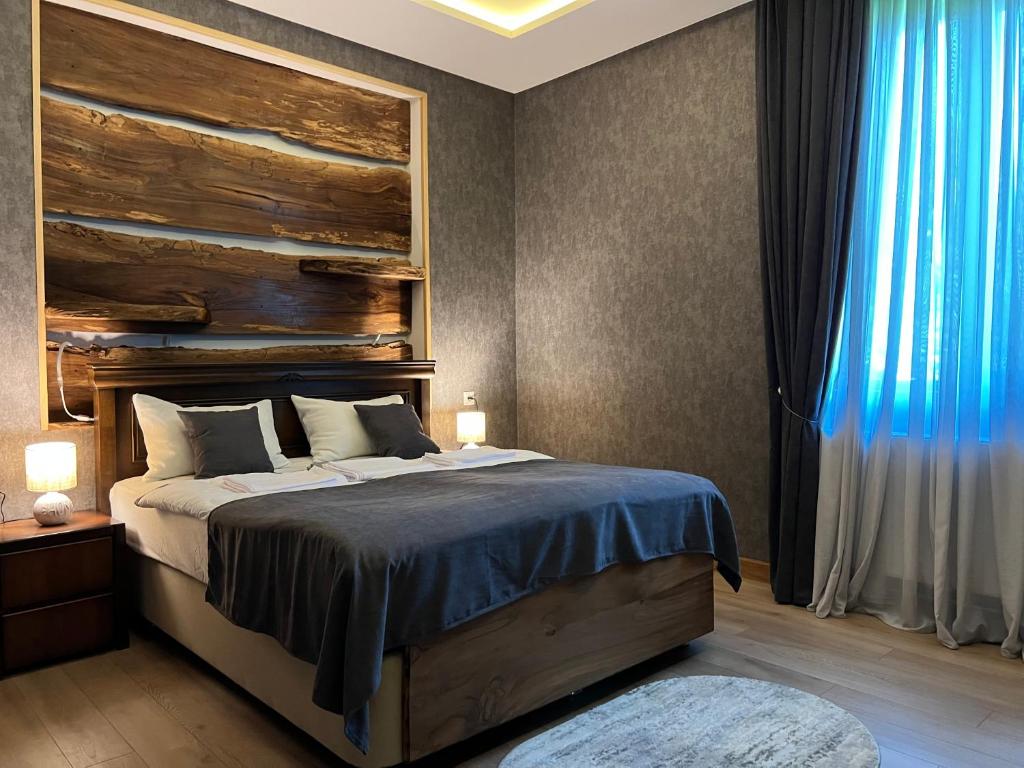 - une chambre avec un lit et une tête de lit en bois dans l'établissement Hotel Nordmann,Racha, à Ambrolaouri