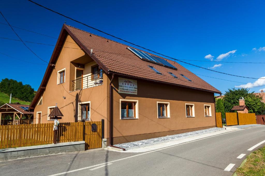 a brown building with a brown roof on a street at Erőss Kulcsosház in Lăzarea