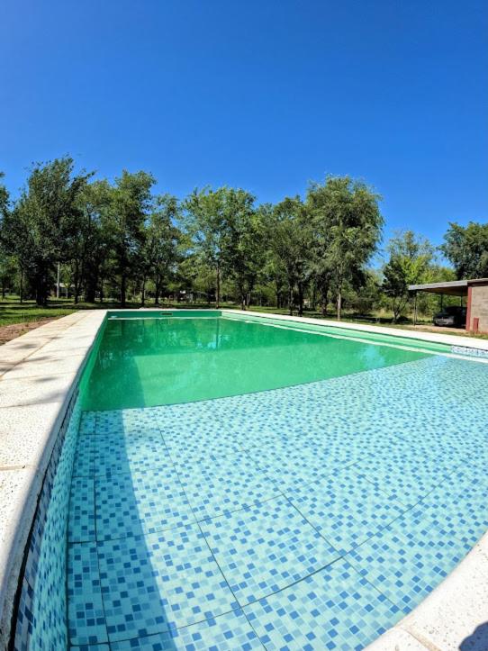 a swimming pool with a green and blue at CABAÑA DORADA in Villa Ciudad de América