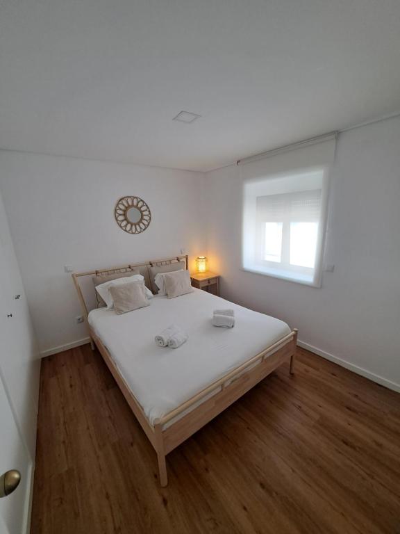 una camera da letto con un grande letto con un orologio sul muro di Beach House a Espinho