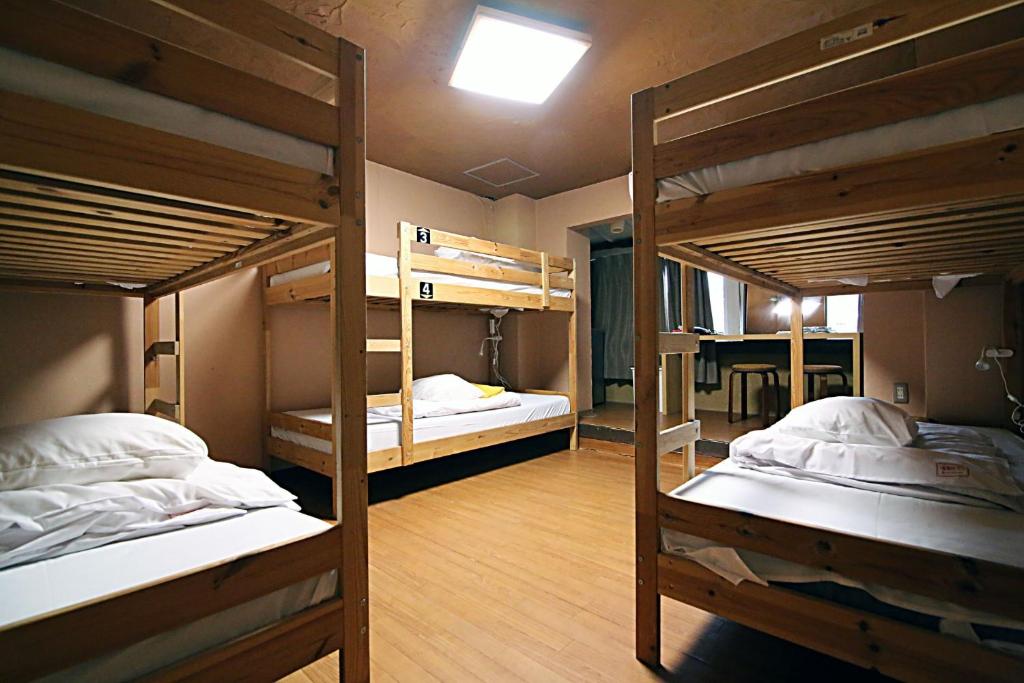 a room with three bunk beds and a table at TOKYO HOUSE INN - Vacation STAY 52051v in Tokyo