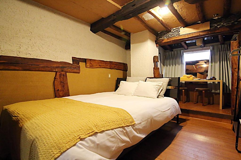 a bedroom with a large bed in a room with a table at TOKYO HOUSE INN - Vacation STAY 52042v in Tokyo