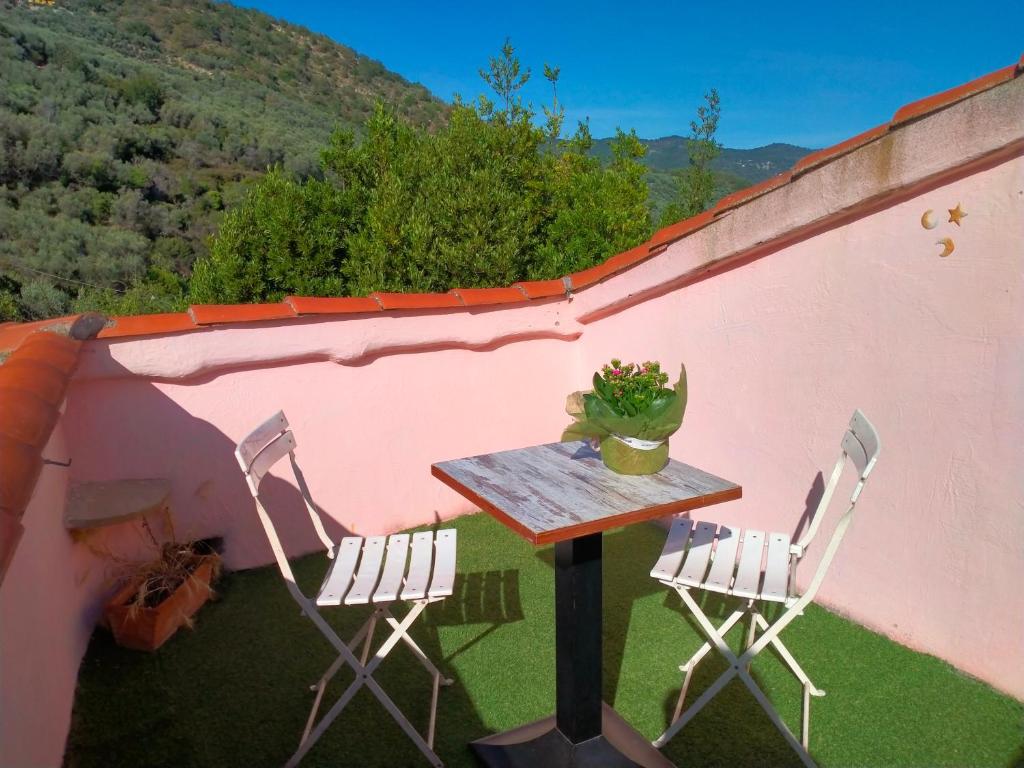 un tavolo e due sedie sul lato di una casa di Thomas casa vacanze a Villa Viani