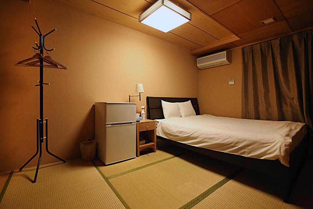 a small room with a bed and a lamp in it at TOKYO HOUSE INN - Vacation STAY 02084v in Tokyo