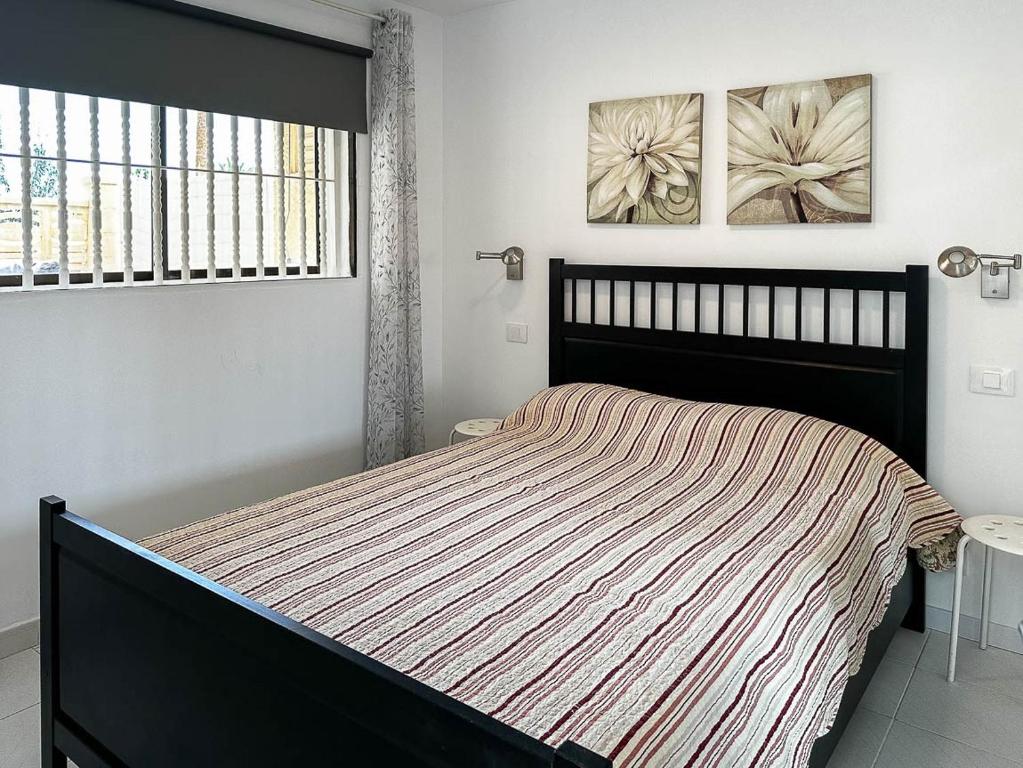 ein Schlafzimmer mit einem großen Bett und einem Fenster in der Unterkunft Apartamento cerca de la playa in Maspalomas